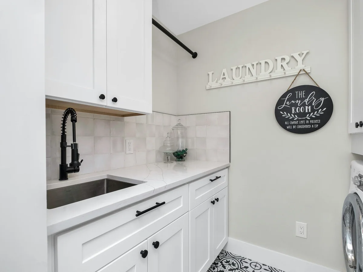 Folding counter and concealed hamper pull-out built into a custom laundry cabinet run
