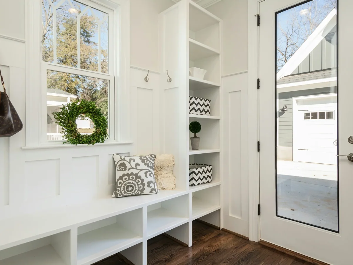 Heavy-duty coat hooks and a slatted boot shelf inside a built-in mudroom locker bay