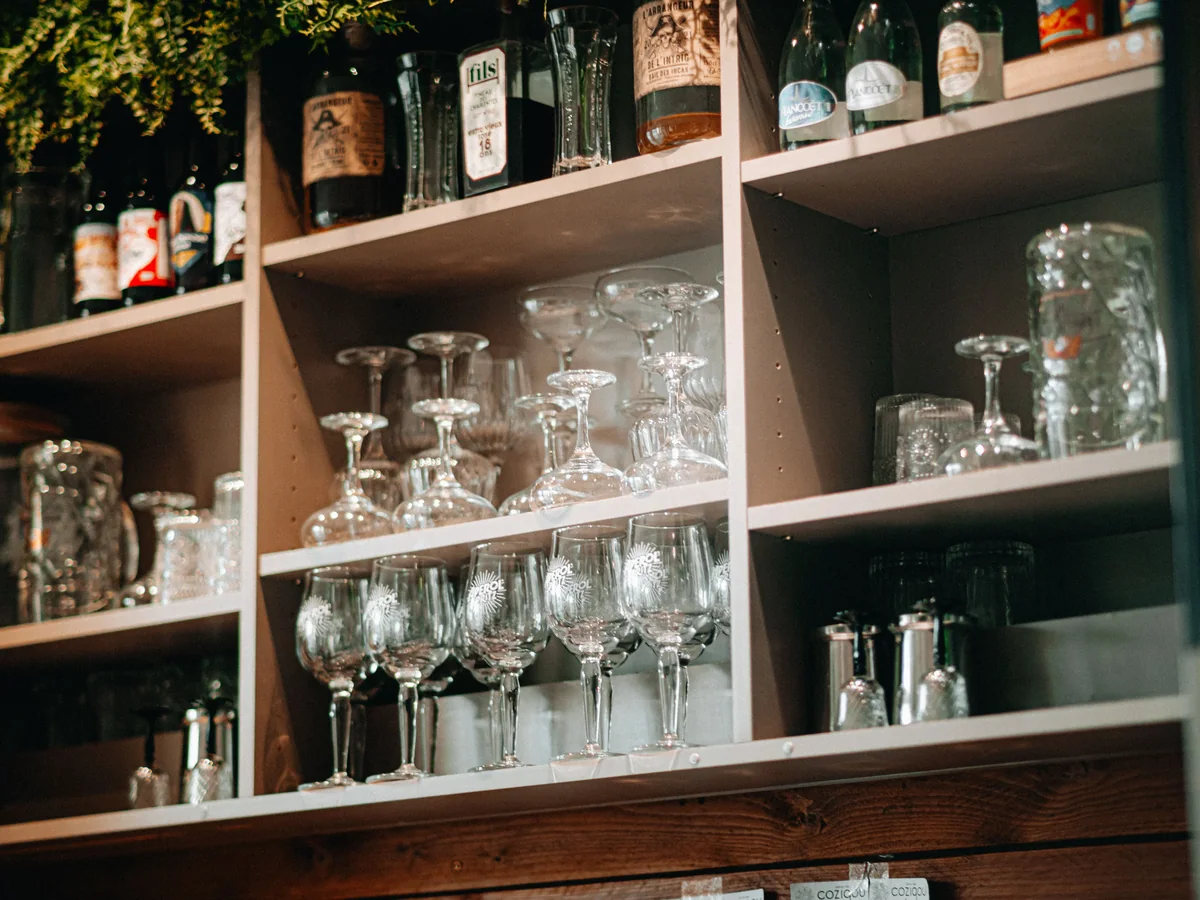 Stemware racking and lit open shelving inside a custom-built residential wet bar